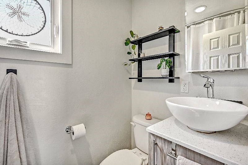 The bathroom offers shelf storage and a full medicine cabinet for additional storage.
