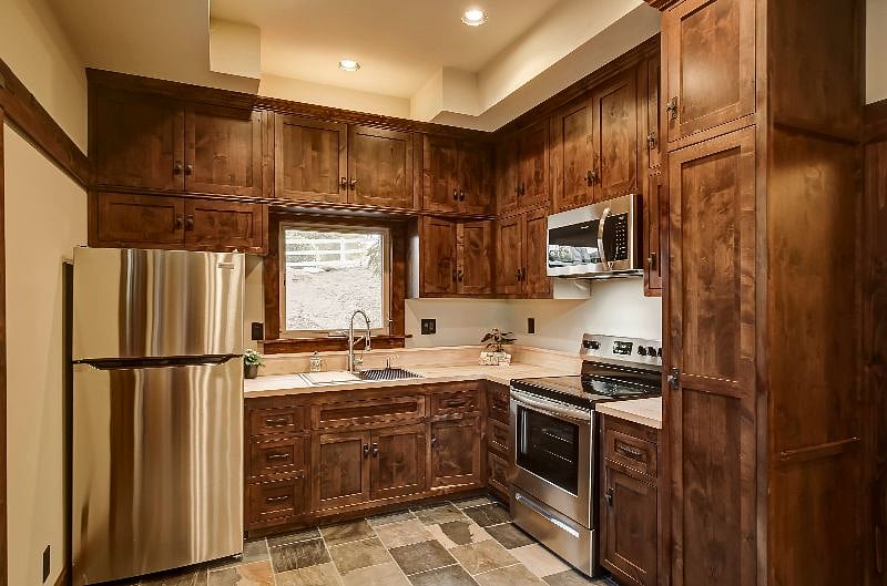 The custom full-size kitchen has floor-to-ceiling alderwood cabinets and comes complete with everything you would find in your own home...and more!