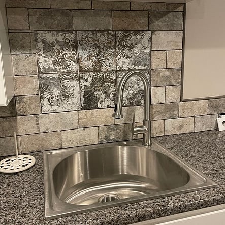 The kitchen sink has a spray faucet and garbage disposal.