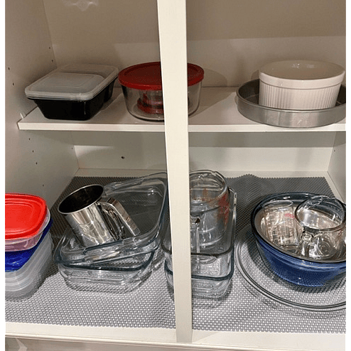 Mixing bowls, storage containers, and baking dishes are convenient to the stove.