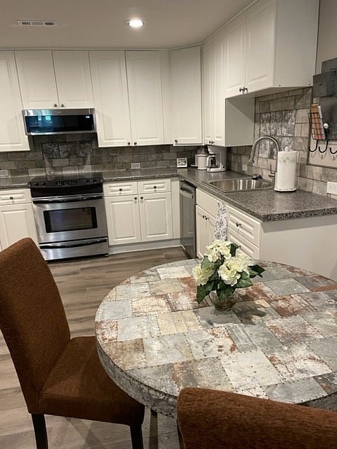 The kitchen has plenty of storage and counter space. A nearby table seats four. The extra chair is in the bedroom.