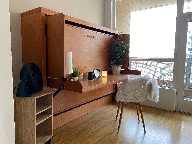 Murphy bed can be folded into a large dedicated work space. Outlet for cords on each end.