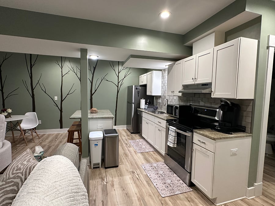 Fully equipped kitchen with an eat-in island features upgrades throughout - granite countertops, stainless steel appliances - including a dishwasher and an automatic ice maker in the freezer, solid painted maple cabinets with slow close action doors and drawers, split level stainless steel sink with an extendable sprayer faucet and garbage disposal, and an oven hood that direct vents to the outside.