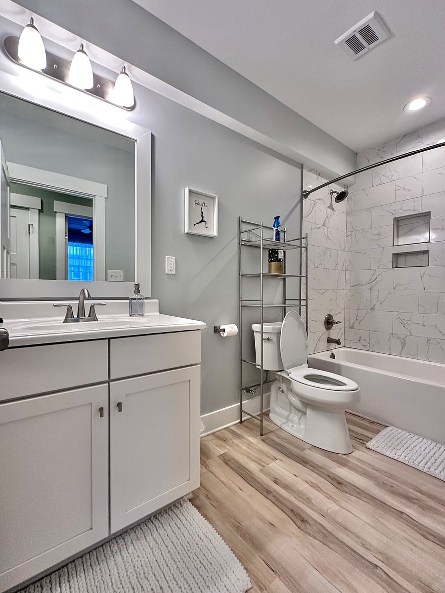 Full-sized spacious bathroom features a tub/shower with tub to ceiling ceramic tile, insets for your showering essentials, and a rain shower head with great water pressure and on-demand hot water ensuring you'll always have a hot shower!