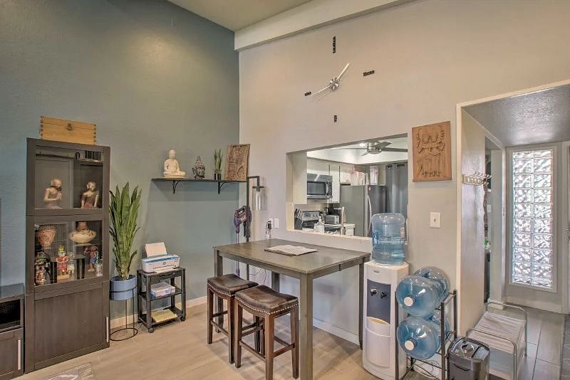 Living room looking into kitchen. Brand new bottom mount hot/cold water dispenser (old one shown in picture) with 3 5 gallon jugs for water. Large dining table with two chairs and 2 stools. There is an insert for the table if you would like to make it larger.