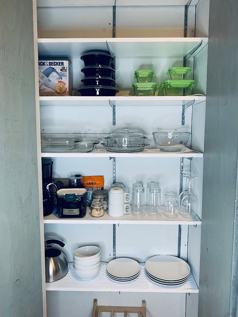 KITCHEN
cabinet full of dishware, glasses, mugs, containers, cooking dishes, hot water kettle, coffee maker, coffee grinder, coffee creamer & sugar