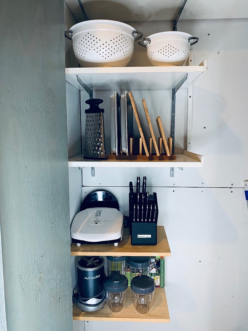 KITCHEN
cabinet full of cutting boards, knife set, baking pans, grater, colanders, sandwich griller, nutri-bullet blender set