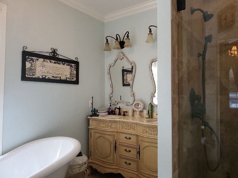 Master bedroom ensuite bath with clawfoot tub and walk-in glass shower.