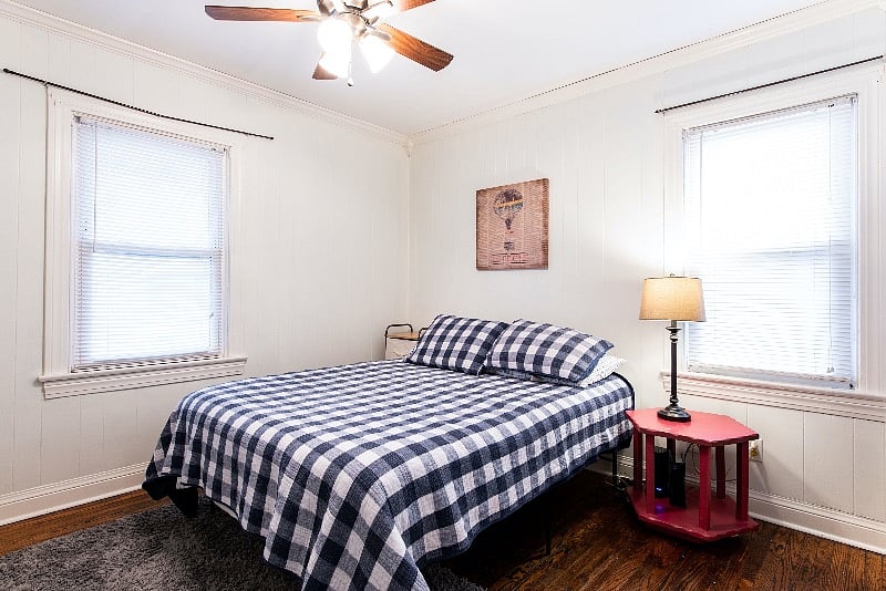 Large bedroom with queen bed, closet and storage shelves. 2 windows for natual light. Curtains have been added for privacy