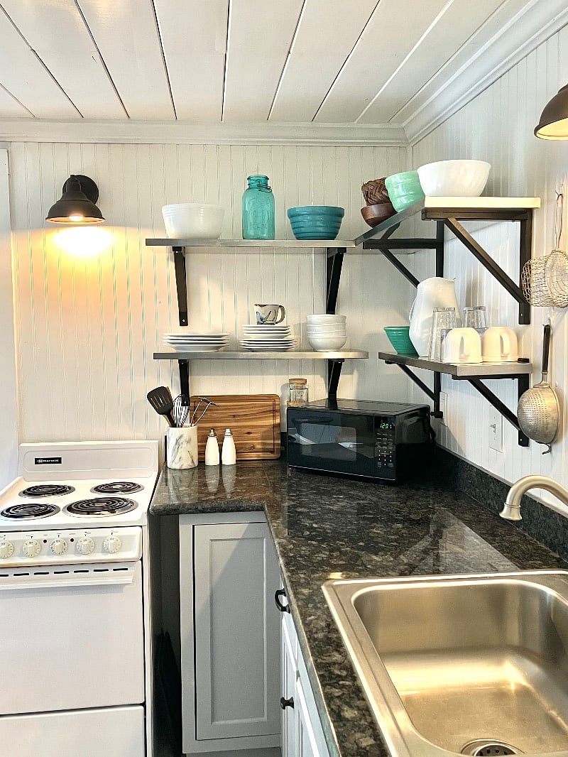 Vintage bowls, microwave, toaster, coffee maker/grinder, blender, and pots and pans included. Black granite counter top.