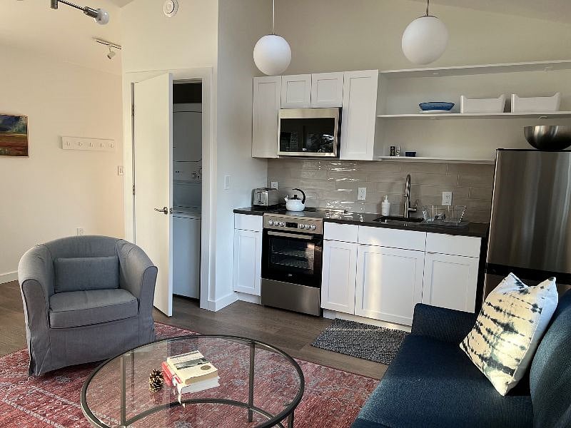 Fully-stocked kitchen, microwave, electric range with oven, refrigerator, and full-size washer dryer