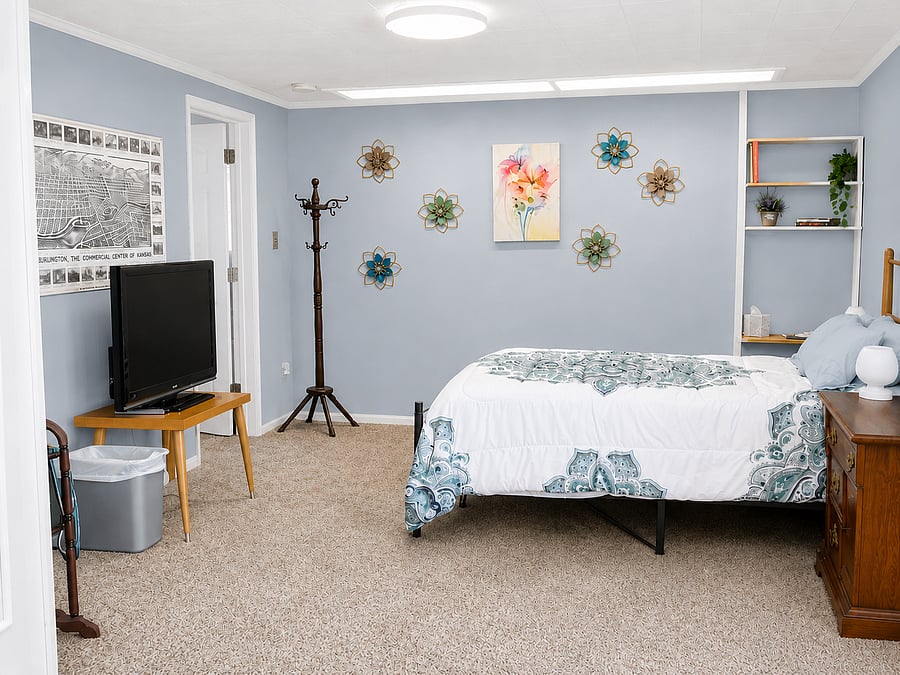 View of primary bedroom from door between living room and bedroom with door to second bedroom.