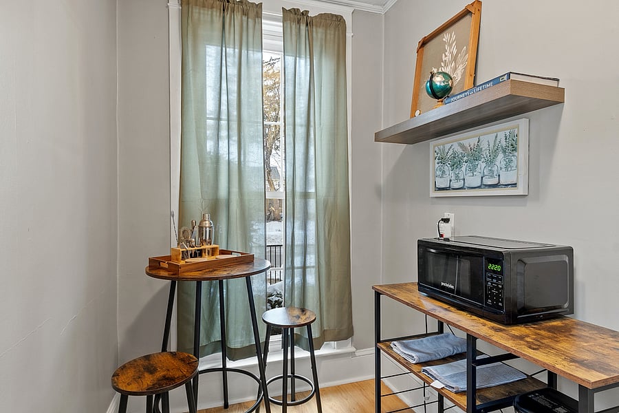 Fully equipped kitchen with coffee maker, microwave, blender, and all cooking essentials. Bar-top seating in front of a gorgeous floor-to-ceiling window provides a bright, welcoming spot to enjoy your meals.