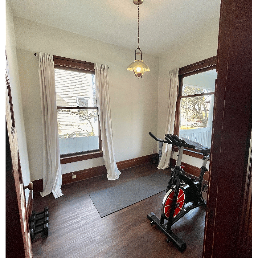 Gym with bike, yoga mats, and free weights