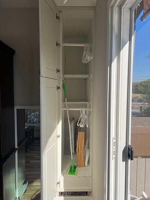 Deep closet with lots of storage space behind the rods.