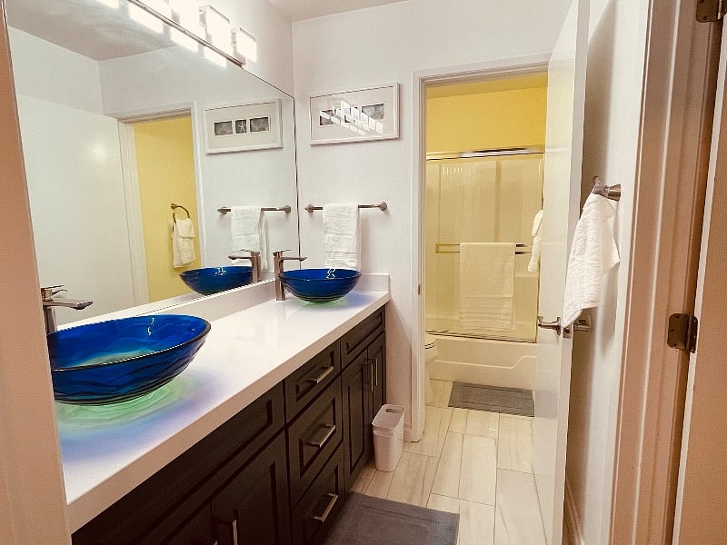 Master suite I bathroom with beautiful double vessel sink vanity, modern lighting & tiled floor