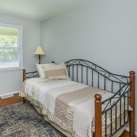 Guest room with twin bed, closet for storage, and dedicated workspace.  