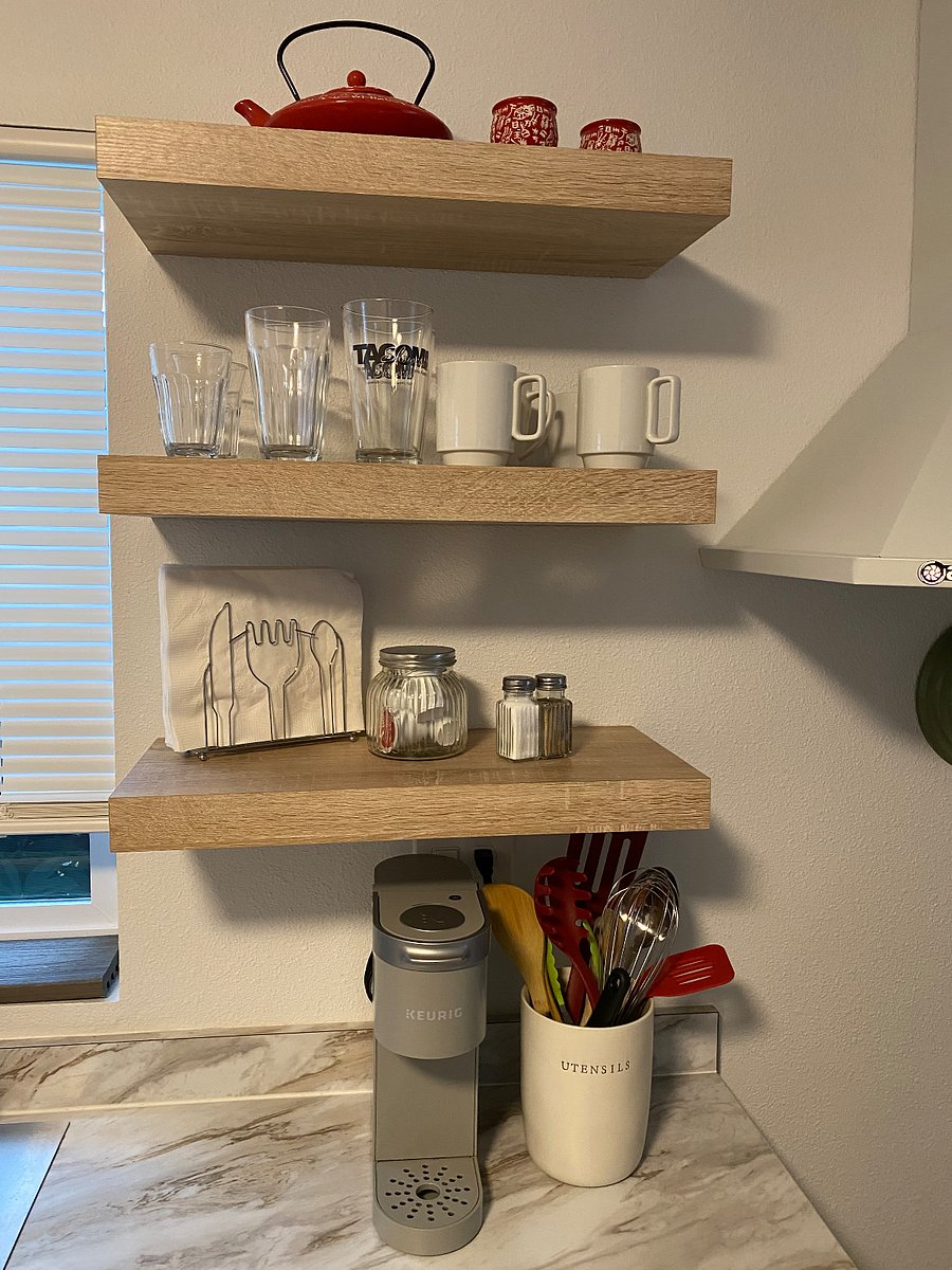 Floating shelves display Glasses, mugs, napkins, starter coffee pods & plates, shelf on other side has even more dishes!
