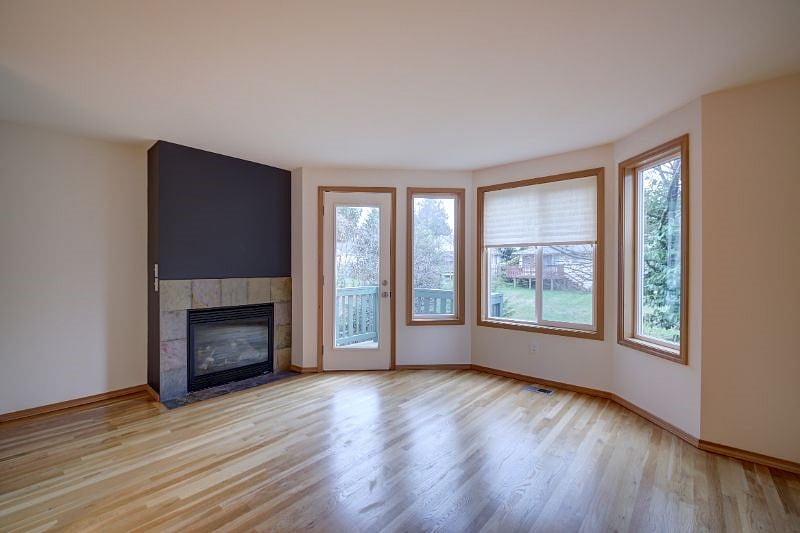 2nd floor, living room with gas fireplace and bay windows to back yard and greenery! There is a balcony off this room.