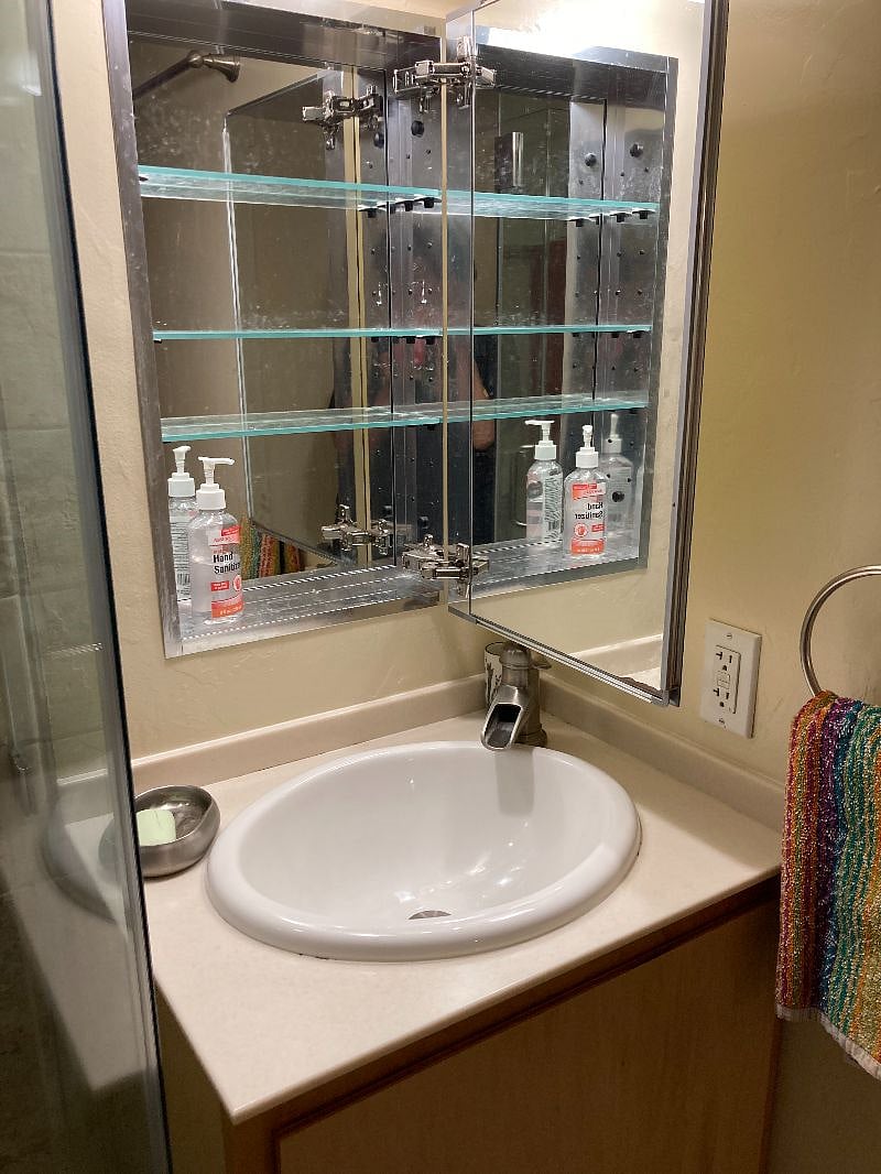 Bathroom mirror cabinet has lots of storage, as well as the sink vanity