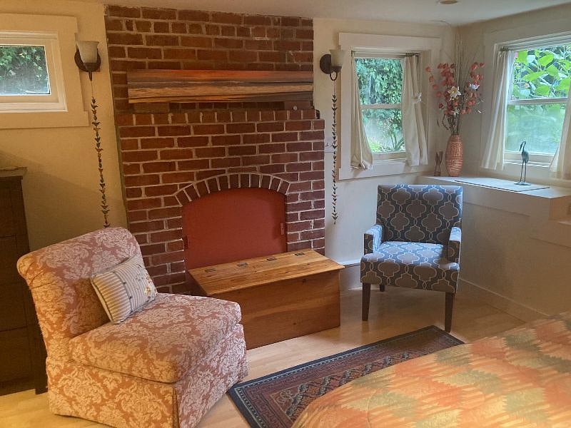 There is a bright overhead reading light over comfy chair by the window