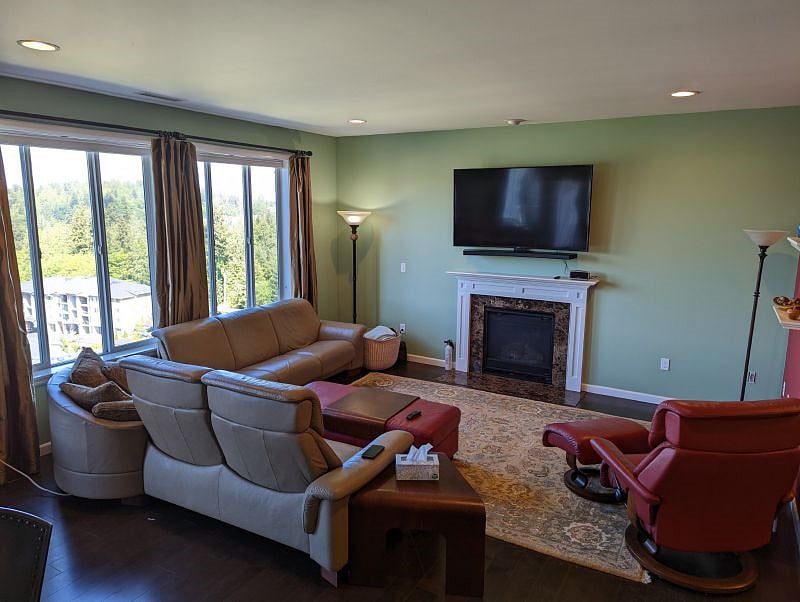 Spacious and beautifully furnished living room with huge windows featuring a stunning western view.