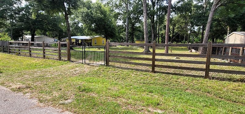 Second metal gate with small driveway . This is the entrance to the property. The house is no longer yellow 