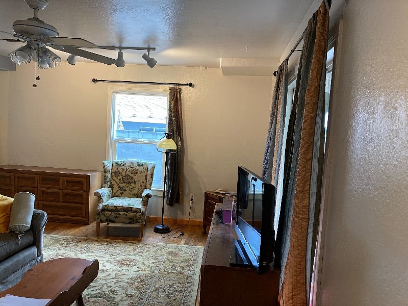 Front living room area with track lighting and overhead fan.