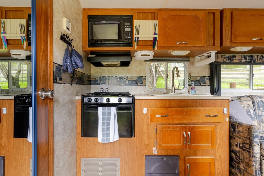 The kitchen has a stove top/oven, microwave, and coffee maker.