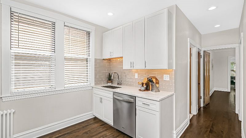 Quartz countertop and artisan tiled backsplash set the tone in the fully remodeled kitchen.