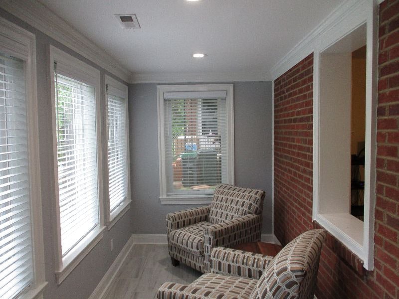 Bright SunRoom with exposed brick wall
