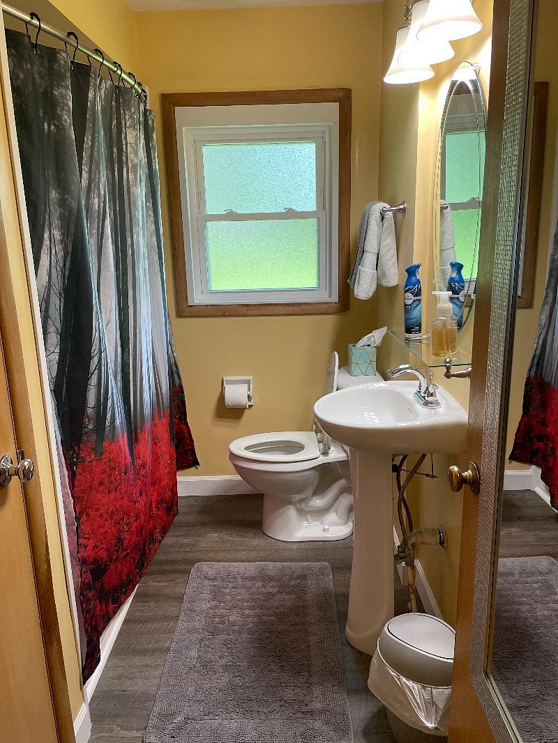 Cozy bathroom with curved shower bar for extra space in shower