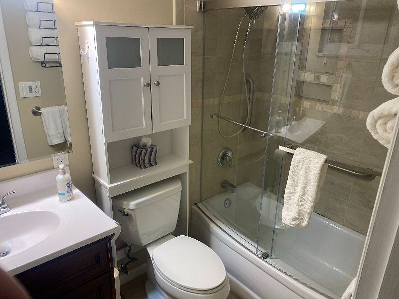 FULLY REMODELED MASTER BATHROOM WITH NEWER VANITY, COMMODE, TILED WAINSCOTTING TUB SHOWER COMBO