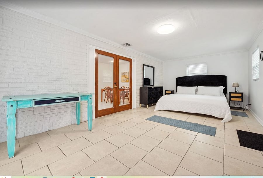 Enormous 4th Bedroom / Florida Room features Private entrance, glass sliding doors to Private Fenced in patio, and King Sized Bed. 