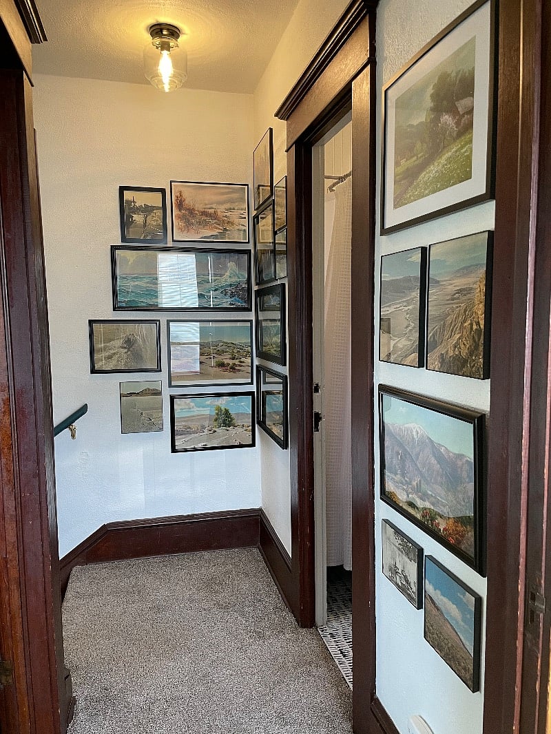 Unique vintage landscapes gallery wall in upstairs hallway. 