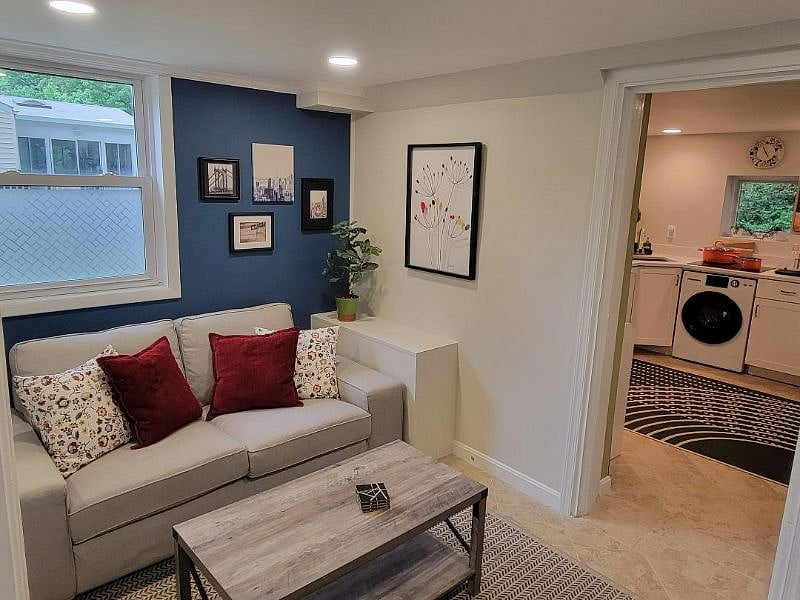Cozy living room area with large flat screen TV and electric fireplace.