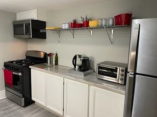 Galley Kitchen with marble counters. Coffee maker, air fryer, blender, and other appliances available.
