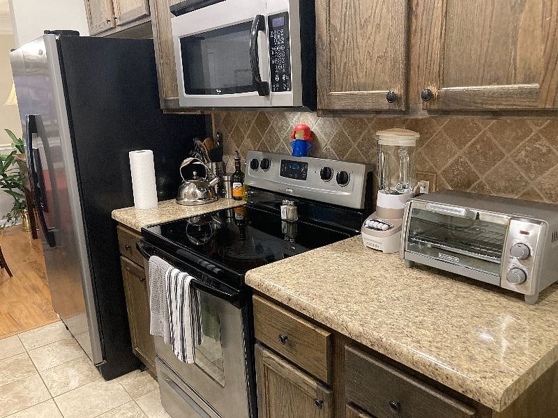 Galley kitchen includes Keurig and drip coffeemakers, an air fryer, toaster oven, blender, tea pot, and microwave.