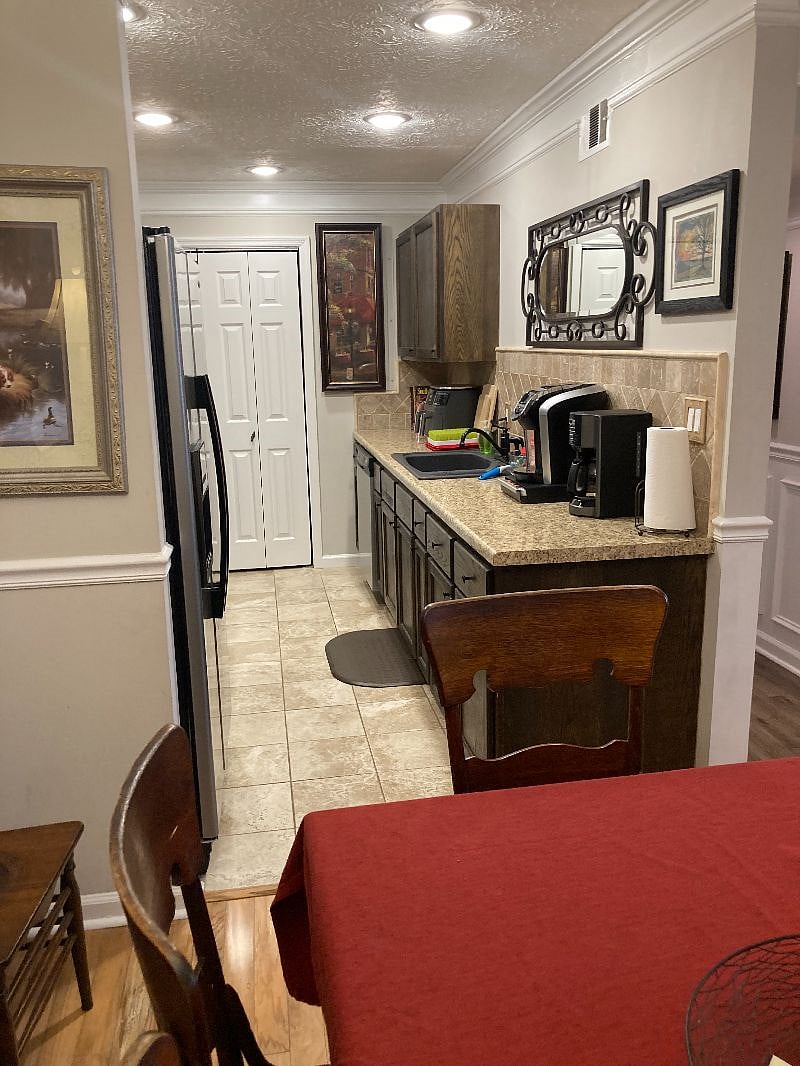 Galley kitchen includes Keurig and drip coffeemakers, an air fryer, toaster oven, blender, tea pot, and microwave.