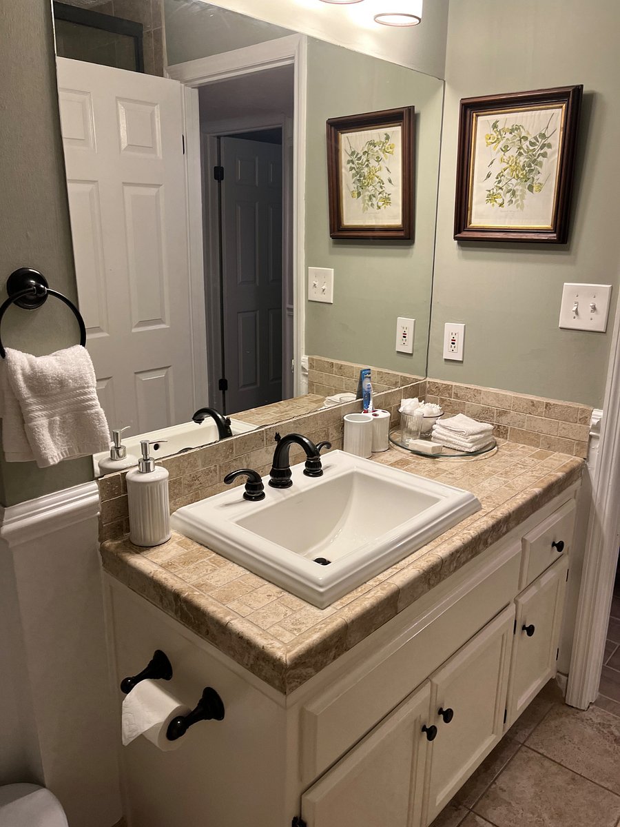 The hall bath features fresh towels, a starter set of soaps, shampoos, a bidet, and a shower / tub combo with fixed and handheld shower heads