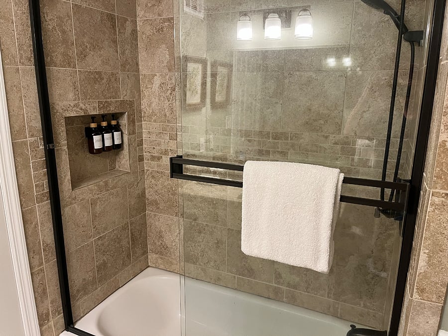 The hall bath features fresh towels, a starter set of soaps, shampoos, a bidet, and a shower / tub combo with fixed and handheld shower heads