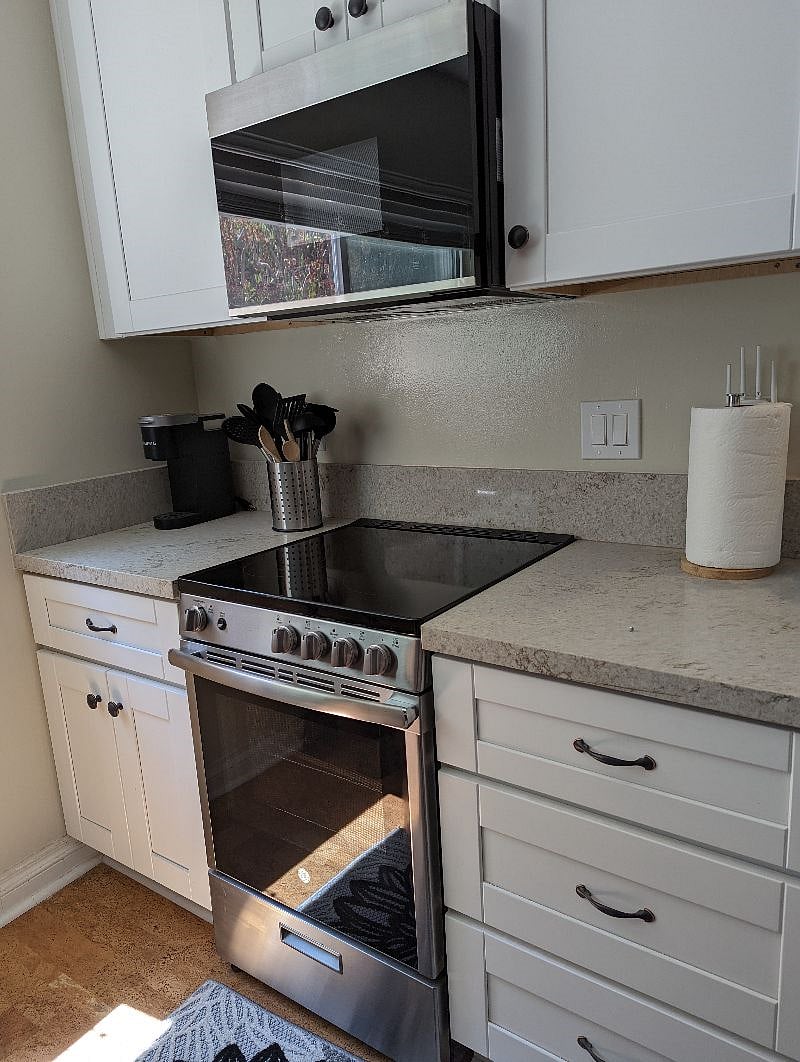 GE glass-top range with over-the-range microwave with built-in vent. Plus a Keurig single cup machine.