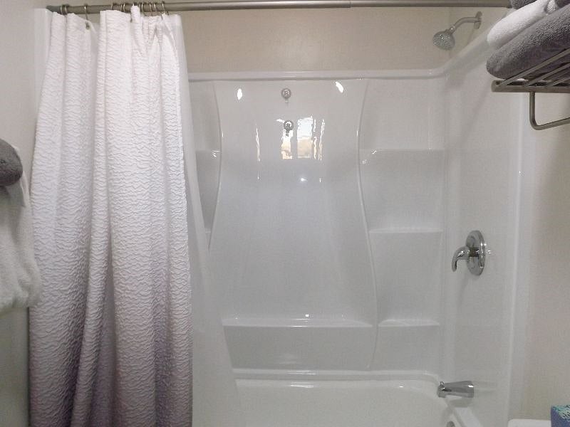 Soaking tub with many wall shelves.