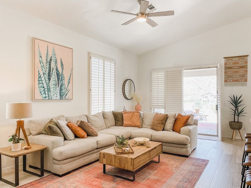 Living room features high ceilings, fan and access to the backyard.