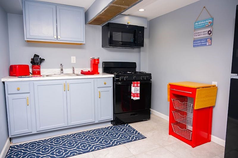 Clean Modern Kitchen with some storage and full fridge.