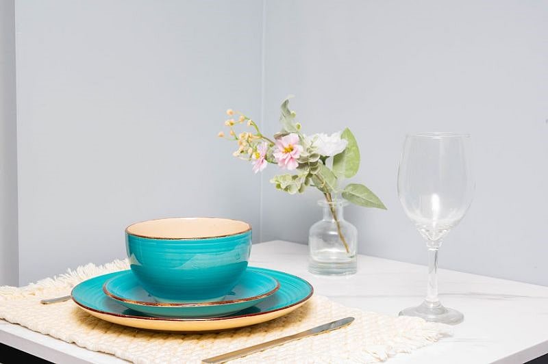Unwind with a glass of wine and a savory meal at the dinette table.