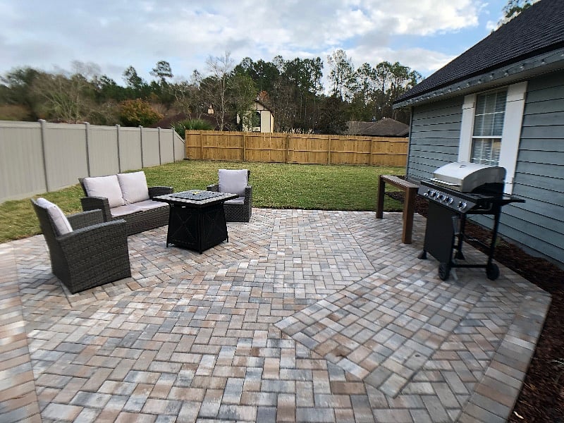 Private backyard with patio seating, grill, and fenced lawn