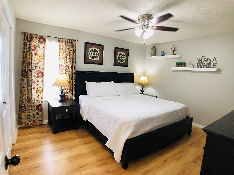 Guest bedroom with king bed, nightstands, and ceiling fan