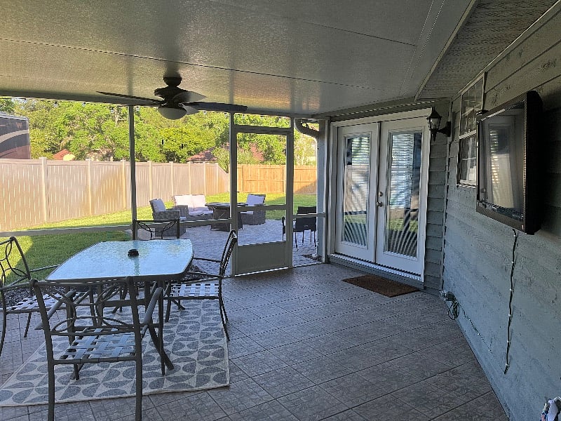 Covered back patio with outdoor seating, Smart TV, and fenced yard
