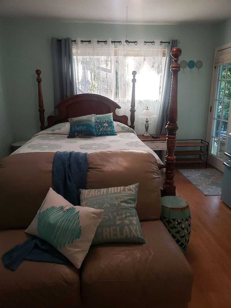 Comfortable bed and sleep area with black out curtains and freshly painted walls.